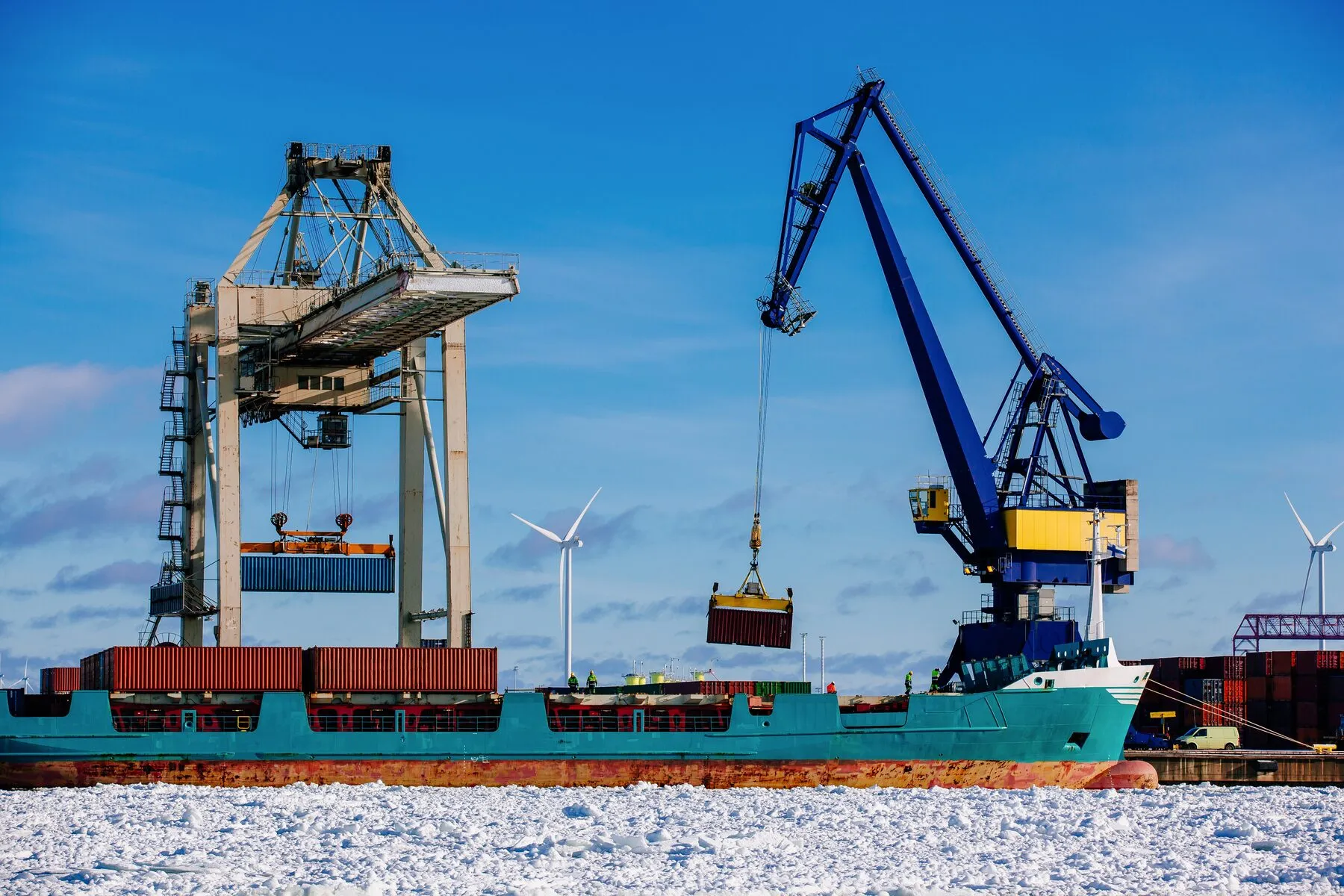 Cargo vessel alongside a quay with cranes working (illustrative)